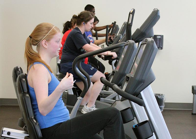 students using eliptical bikes at fitness center