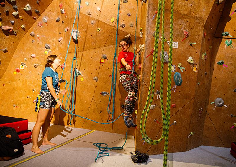 female students using climbing wall